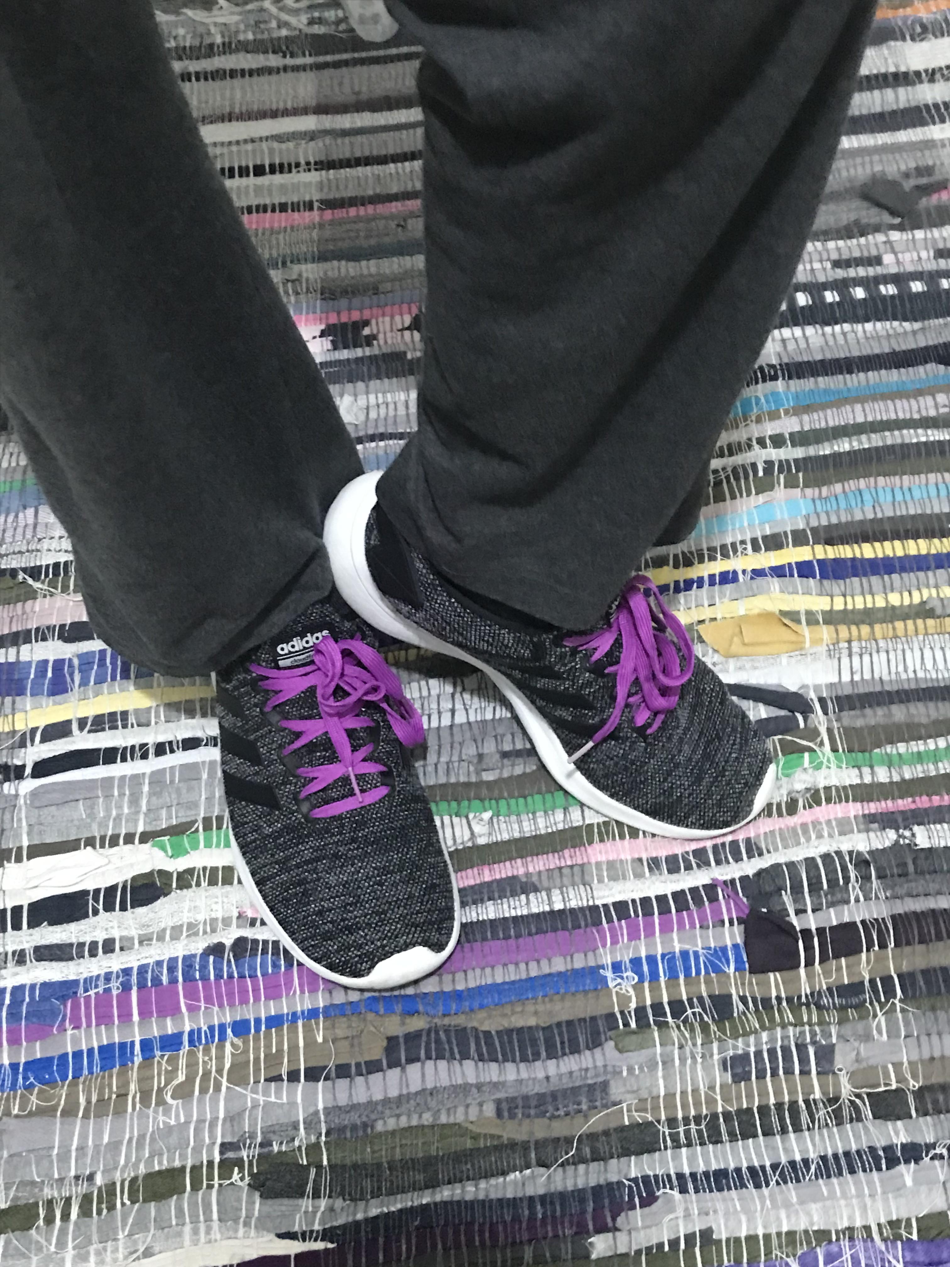 Me wearing dark gray shoes with a white sole, laces are purple. Only lower part of my legs is visible.